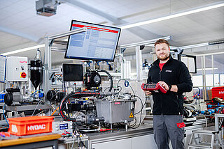 HYDAC employee in production working with a HMG 4000 data recorder and measuring device.